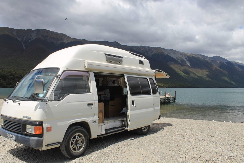 viajar por nueva zelanda fotografía de una furgoneta al lado de un lago